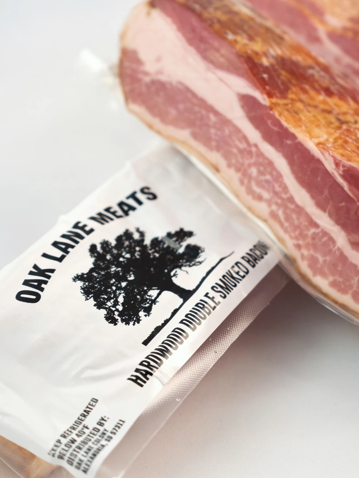 Oak Lane Meats packages of bacon showing the Oak Lane Meats logo and product information